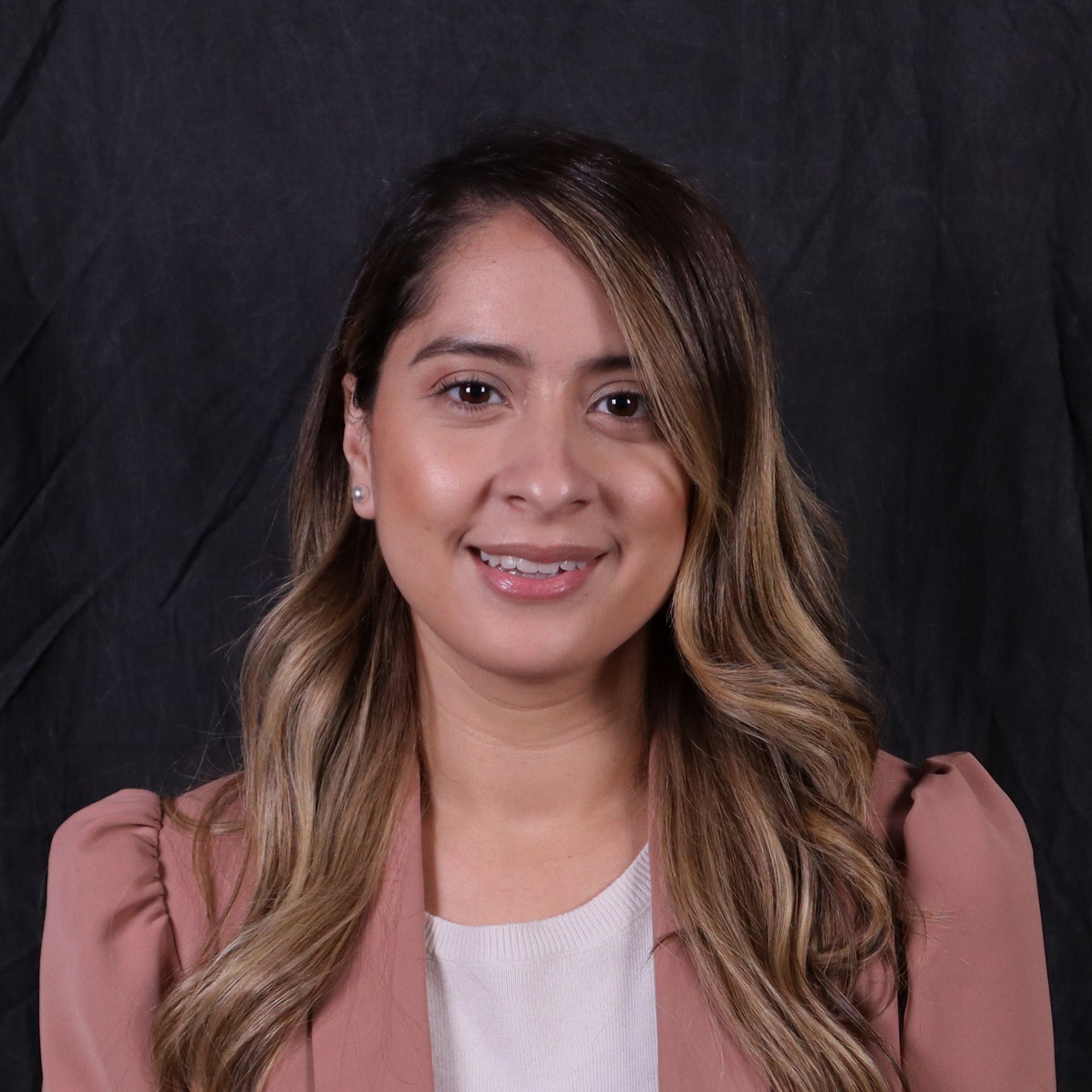 Headshot of Amy Aguirre with a business casual top against a dark background.